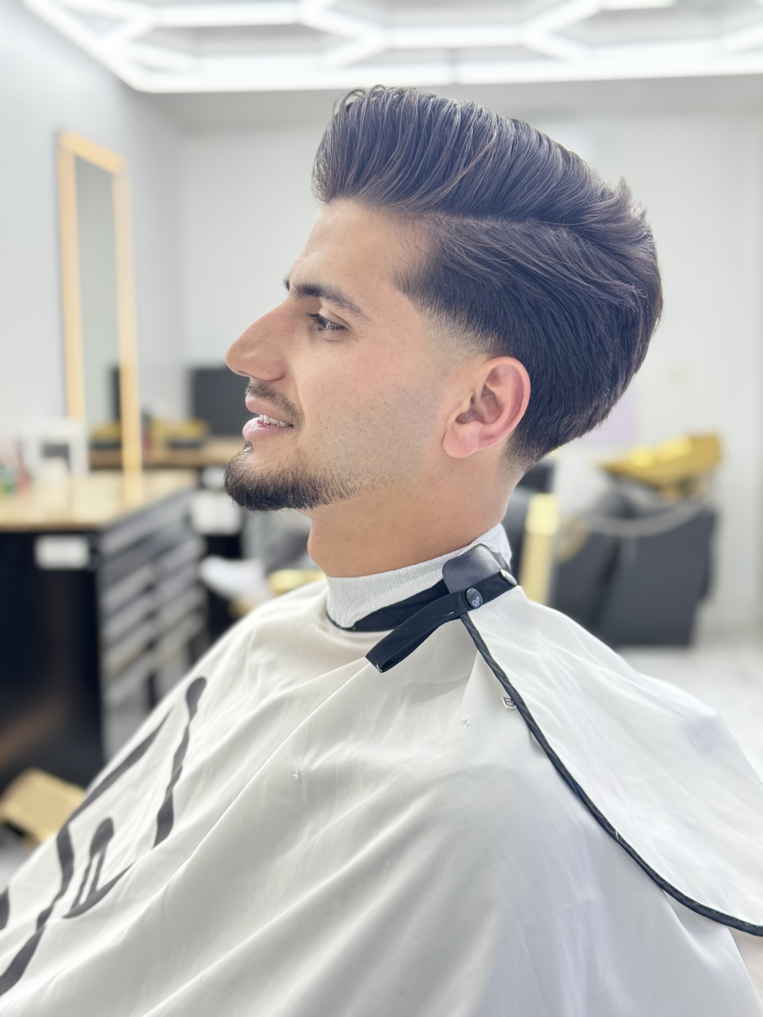 Slick pompadour with skin fade and beard