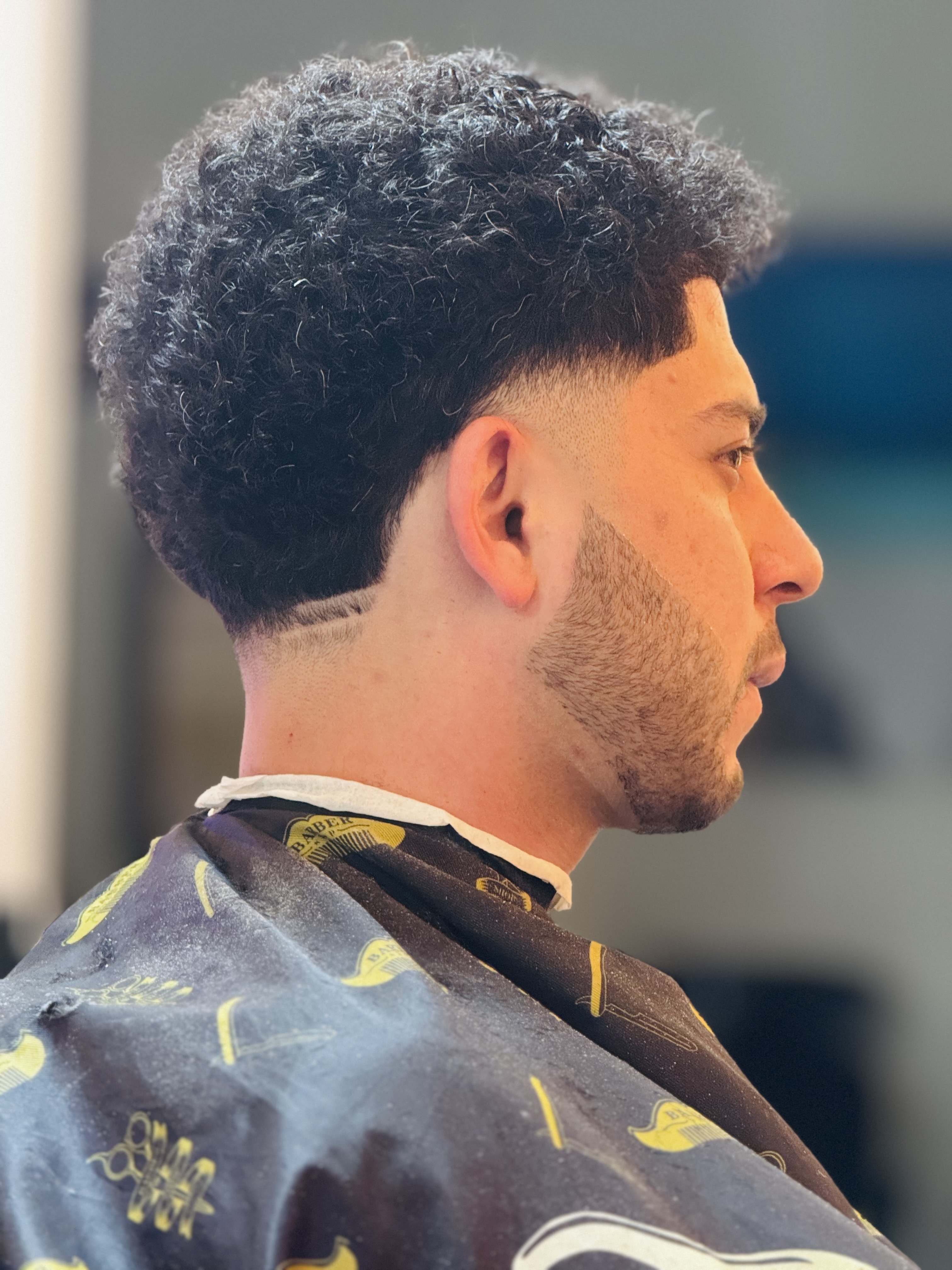 Curly afro top with skin fade and neckline design